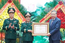 Le secrétaire général du PCV, To Lam (à droite), remet le titre de Héros des Forces armées populaires au Département général de la Logistique et de la Technique relevant du ministère de la Défense. Photo : VNA.