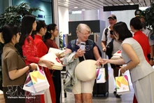 Offre des cadeaux aux passagers venus de Manille (Philippines) et de Bali (Indonésie). Photo : VNA.