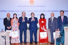 Le Premier ministre Pham Minh Chinh (au centre) remet des cadeaux à la communauté vietnamienne en Russie. Photo : VNA.
