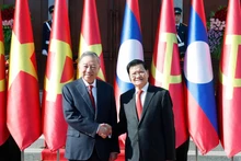 Le secrétaire général du PPRL et président du Laos, Thongloun Sisoulith (à droite) et le secrétaire général du PCV, To Lam, en visite d’État au Laos. Photo : VNA.