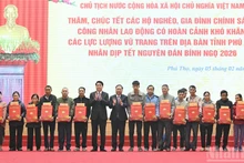 Le président Luong Cuong et Nguyen Phi Long, secrétaire adjoint du Comité du Parti du Front de la Patrie du Vietnam et des organisations centrales de masse, remettent des cadeaux à la population de la province de Phu Tho.