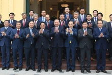 Le secrétaire général To Lam et le Premier ministre Pham Minh Chinh aux côtés des ambassadeurs et des chefs des représentations diplomatiques du Vietnam à l'étranger participant au XIVᵉ Congrès national du PCV.