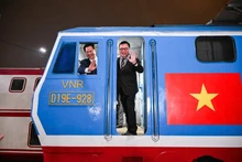 Le Quoc Minh, le rédacteur en chef du Journal Nhân Dân, et Dang Sy Manh, président du Conseil des membres de la Compagnie nationale des chemins de fer du Vietnam, à bord du « Train du Bonheur » dans la nuit du réveillon.
