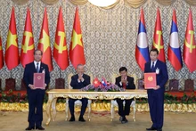 Le secrétaire général To Lam et le secrétaire général du PPRL et président lao, Thongloun Sisoulith, supervisent l’échange des accords de coopération entre les deux pays. Photo : VNA.