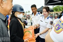 Les officiers et soldats de la garde-côtière remettant directement des produits de première nécessité à la population lors du marché solidaire.