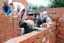 Des officiers et des soldats du commandement de défense de la zone 1 - Son Tinh, relevant du commandement militaire provincial de Quang Ngai, construisent des maisons pour des familles locales. Photo : VNA