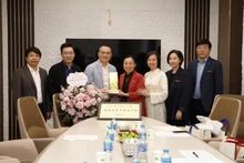 Long Nina (en rouge), vice-rectrice de l’Université normale de Nanning, remet un cadeau souvenir à un représentant de la “Maison des anciens étudiants vietnamiens”. Photo : Comité d’organisation.