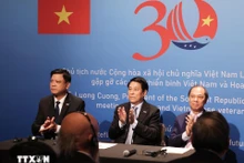 Le président vietnamien Luong Cuong (au centre) à la rencontre des vétérans vietnamiens et américains. Photo : VNA.