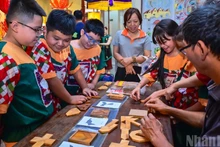 Les élèves de l’école primaire Tran Nhat Duat participent avec enthousiasme au jeu Tri Uan dans l’espace culturel et artistique de Hang Buom, à Hanoi, capitale vietnamienne.