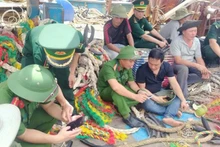 Des soldats du poste de garde-frontière de Quynh Phuong, en coordination avec la police, ont mené une campagne de vulgarisation numérique auprès des équipages de bateaux de pêche. Photo : NDEL.