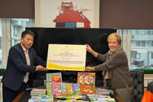 Pham Vinh Thai (gauche), rédacteur en chef de la Maison d'édition de l'Éducation du Vietnam, a fait don de nombreux livres pour enfants et manuels d'enseignement de vietnamien à la Bibliothèque. Photo : Maison d'édition de l’Éducation du Vietnam.