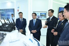 Le Premier ministre Pham Minh Chinh (2e, de gauche à droite) visite la salle des traditions et des produits technologiques de VNPT. Photo : NDEL.