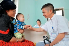 Le docteur Nguyen Duy Dong examine un petit patient au poste médical de Lung Cu.