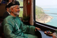 Un touriste étranger, vêtu d’áo dài, a admiré le paysage du col de Hai Van et de la baie de Lang Co à travers la fenêtre. Photo : Znews.