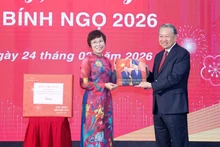 La directrice générale de la VNA, Vu Viêt Trang, remet au secrétaire général Tô Lâm un livre de photos réalisé par les journalistes du Département de rédaction des photos de presse. Photo : VNA.