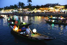 Un habitant taille des pots de fleurs décoratifs devant sa maison, se préparant à accueillir les visiteurs.