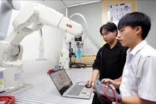 Des étudiants testent des algorithmes de commande d’un bras robotique au laboratoire de robotique de l’Université d’Industrie de Hô Chi Minh-Ville. Photo : VNA.