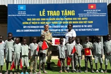 Le Lieutenant-colonel Trần Thanh Sơn, Commandant adjoint de l'unité de génie no 4, remet des fournitures scolaires aux élèves d'Abyei. Photo : Hai Yen.