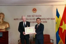 L'ambassadeur Trần Văn Tuấn remet la médaille pour la cause de la culture, des sports et du tourisme au réalisateur de cinéma Bo Öhlén. (Photo: Ambassade du Vietnam en Suède)