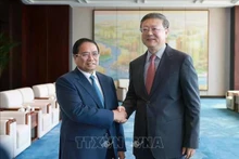 Le Premier ministre Pham Minh Chinh (gauche) et Chen Jining, membre du Bureau politique du Comité central du Parti communiste chinois (PCC) et secrétaire du Comité du PCC pour la ville de Shanghai. Photo: VNA