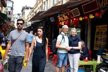 Touristes étrangers visitant le vieux quartier de Hanoi avec ses marchés, la street food, les spectacles traditionnels et ses sites historiques. Photo : VNA.
