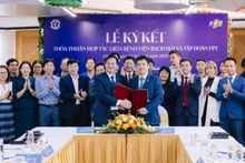 Đao Xuan Co, directeur de l'Hôpital Bach Mai et Nguyên Van Khoa, directeur général du Groupe FPT, échangeant l'accord de coopération.