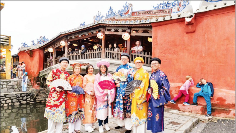 Des touristes portant des costumes traditionnels vietnamiens explorent la vieille ville de Hoi An (Da Nang). Photo : NDEL 