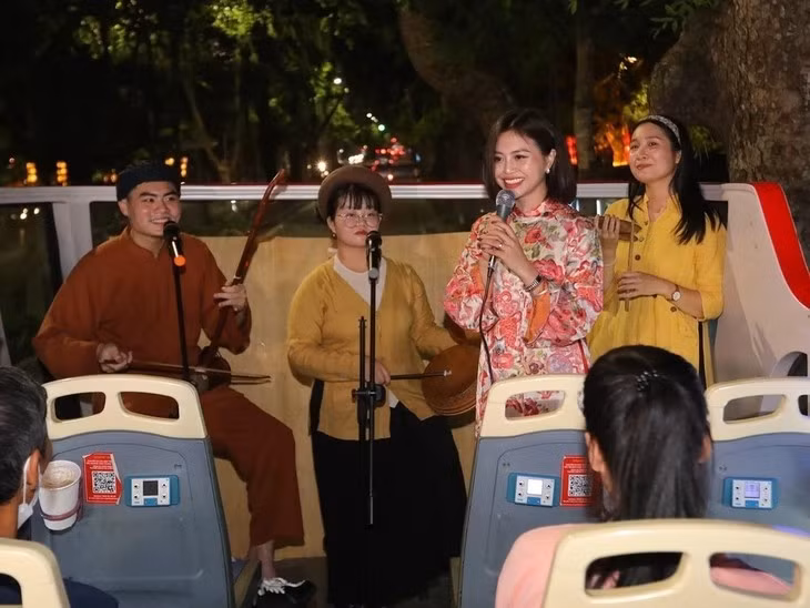 Une passagère prend part à une séance d’échange avec des artistes de Xâm. Photo : VNA.