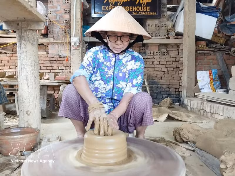 Le village compte actuellement 32 ateliers, dont quatre spécialisés dans la céramique traditionnelle, employant directement une soixantaine d'artisans. Photo: VNA