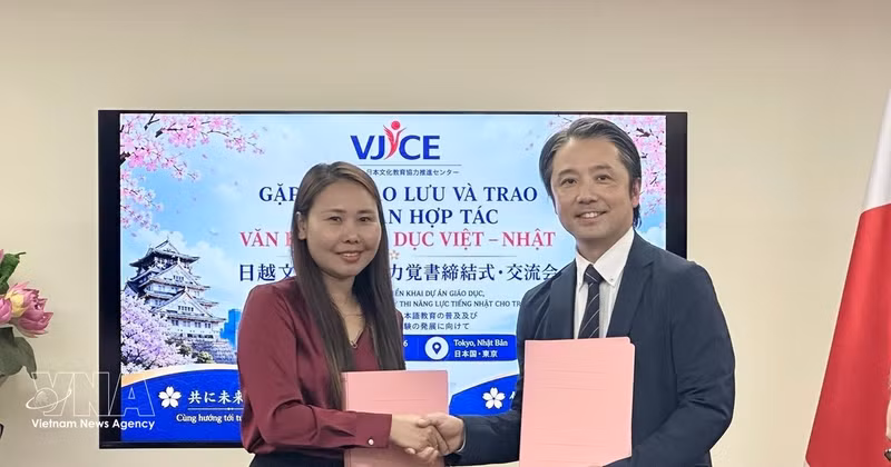 Les représentants du VJCE et de l'École de langue japonaise Aoyama procèdent à l'échange de l'accord de coopération signé. Photo : VNA. 