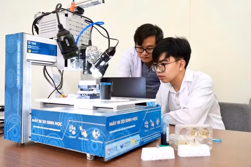 Une imprimante 3D biologique développée par une équipe de scientifiques de l'Université nationale de Hanoï, dirigée par le professeur associé et docteur Nguyen Ngoc Dinh (à gauche). Photo : NDEL
