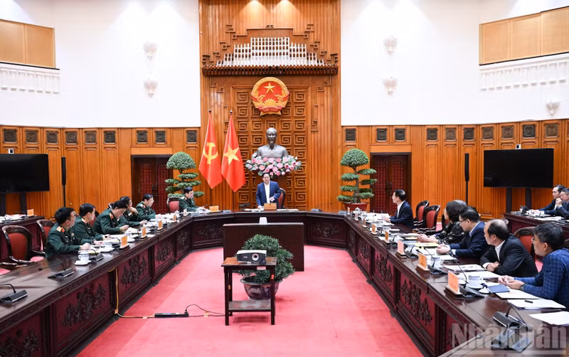 Le Premier ministre Pham Minh Chinh (debout) lors de la séance de travail avec des représentants du ministère de la Défense et des ministères et secteurs concernés. Photo : Tran Hai/NDEL