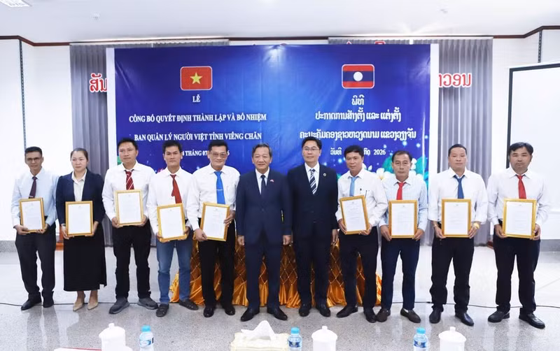Les représentants de Vientiane remettent la décision sur la création de l’Association des Vietnamiens de cette province. Photo : VNA