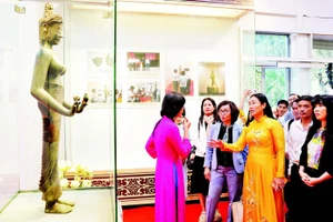 Des visiteurs admirent l’originale de la statue du Bodhisattva Tara, classée trésor national, dans l’espace d’exposition « Trésors nationaux – Un patrimoine au cœur de Da Nang ».