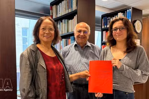 La chercheuse culturelle Tran Thu Dung (à gauche), Yonnel Ghernaouti, membre du conseil d'administration de l'Institut maçonnique de France, et Emma Lallemand, bibliothécaire au GODF, posent avec des documents d'archives sur Nguyên Ai Quôc. Photo : VNA. 