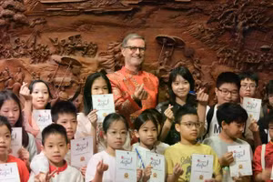 L’ambassadeur de France au Vietnam pose pour une photo souvenir avec les élèves participant au concours de dictée francophone au Temple de la Littérature – Quoc Tu Giam. (Photo : baoquocte)