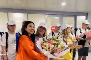 La directrice du Département du tourisme de Hanoï, Dang Huong Giang, offre des fleurs pour féliciter le 5 millionième visiteur international et une délégation espagnole à l'aéroport de Noi Bai, le 7 juillet 2026 après-midi. Photo : VNA 