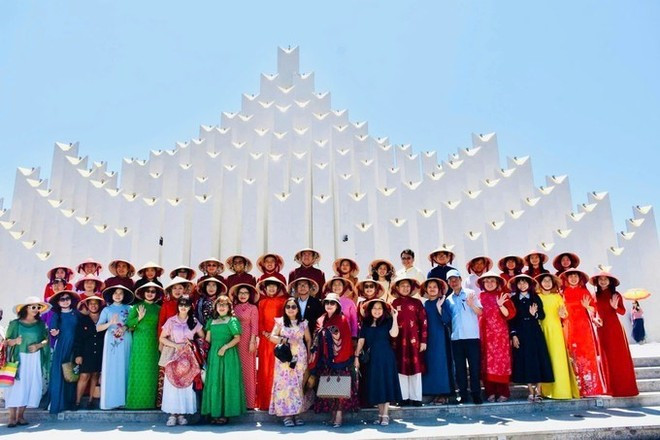 Les délégués et les visiteurs devant la tour Tam Thang, un monument architectural emblématique de Ho Chi Minh-Ville.