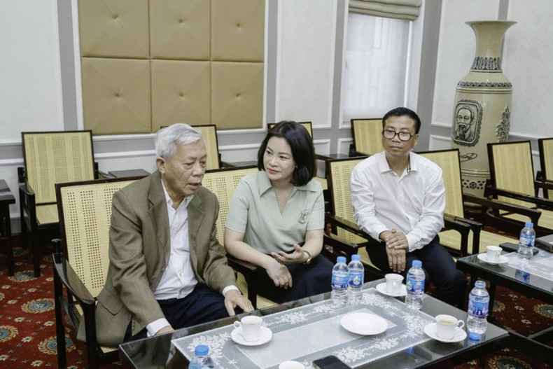 Le poète Nguyen Khoa Diem échange autour de l’œuvre en laque « l’Oncle Hô lit la Déclaration d'indépendance ». Photo : NDEl. poete-echange.jpg