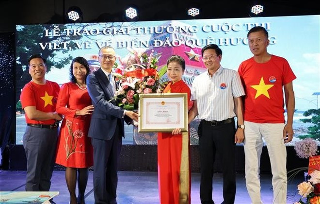 L’ambassadeur du Vietnam en Allemagne, Vu Quang Minh, remet un satisfecit à Bui Thi Thu Minh, cheffe du Comité de liaison des Vietnamiens en Europe « Pour la mer et les îles du Vietnam » et présidente du Club Truong Sa en Allemagne. Photo : VNA. L’ambassadeur du Vietnam en Allemagne, Vu Quang Minh, remet un satisfecit à Bui Thi Thu Minh, cheffe du Comité de liaison des Vietnamiens en Europe « Pour la mer et les îles du Vietnam » et présidente du Club Truong Sa en Allemagne. Photo : VNA.