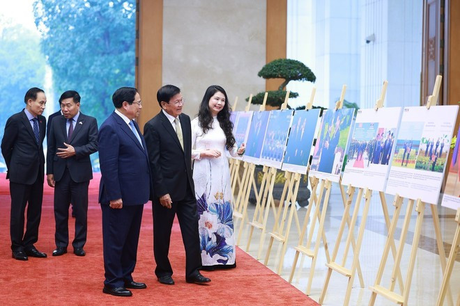 Le Premier ministre Pham Minh Chinh et le secrétaire général du PPRL et président du Laos, Thongloun Sisoulith, visitent une exposition de photos sur la coopération bilatérale, organisée par l'Agence vietnamienne d'Information (VNA). Photo : VNA.