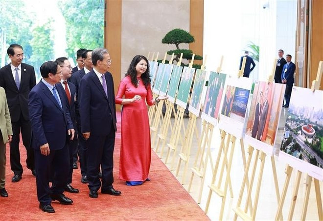 Le Premier ministre vietnamien Phạm Minh Chính et Zhao Leji, président du Comité permanent de l’Assemblée populaire nationale de Chine, lors de l'exposition de photographies sur les relations de coopération entre le Vietnam et la Chine, organisée par l’Agence vietnamienne d’Information (VNA). Photo : VNA. Le Premier ministre vietnamien Phạm Minh Chính et Zhao Leji, président du Comité permanent de l’Assemblée populaire nationale de Chine, lors de l'exposition de photographies sur les relations de coopération entre le Vietnam et la Chine, organisée par l’Agence vietnamienne d’Information (VNA). Photo : VNA.