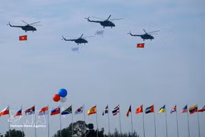 Un vol de formation d’hélicoptères arborant le drapeau national vietnamien effectue une démonstration aérienne lors de la cérémonie d’ouverture de l’Exposition internationale de défense du Vietnam 2024. Photo : VNA