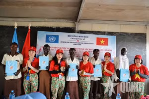 Des représentantes de l’antenne de l’Union des femmes vietnamiennes de l’équipe du génie no 5 remettent des cadeaux aux élèves méritantes. Photo : qdnd.vn