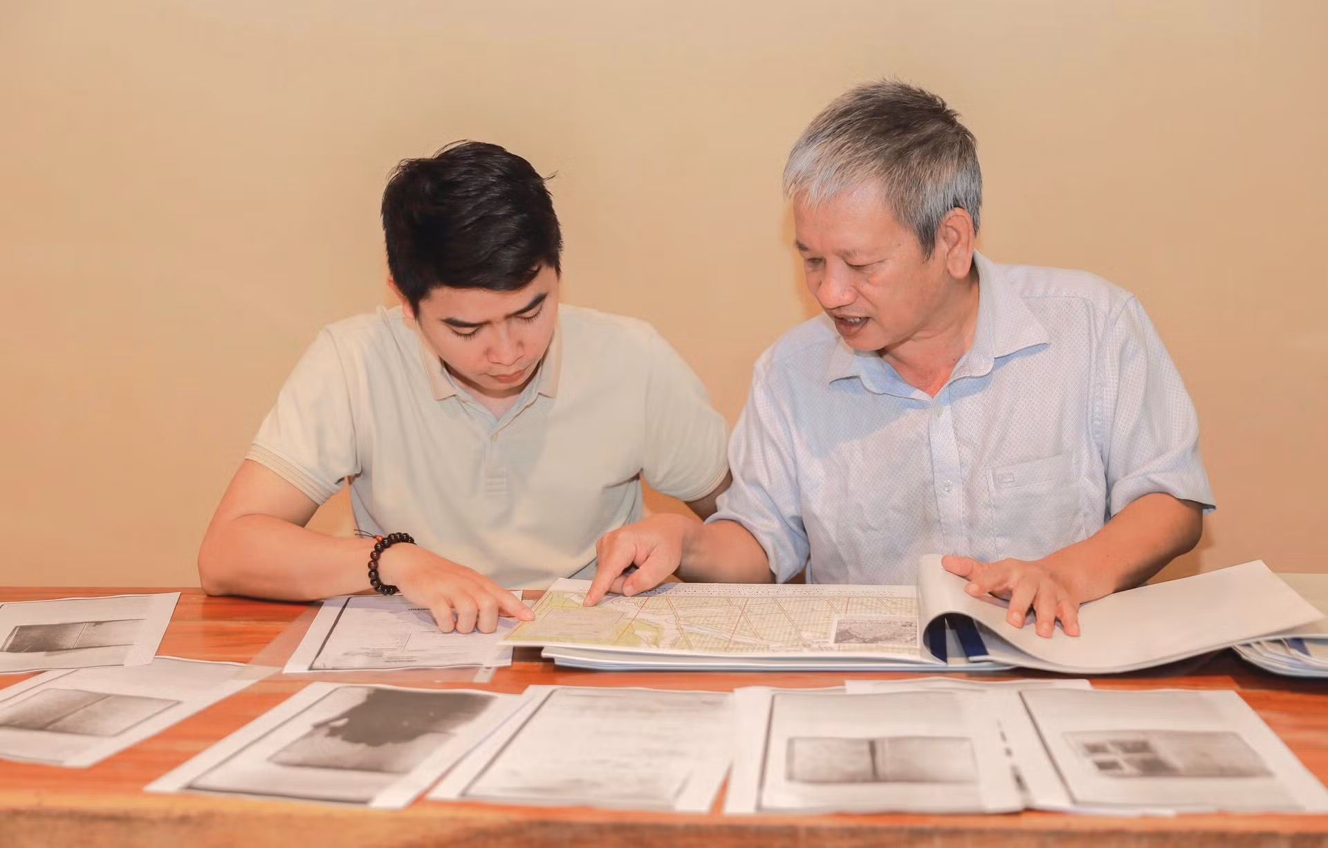 L’architecte Nguyen Xuan Thang (droite) examine minutieusement des photographies historiques de 1968 pour localiser les fosses communes des martyrs dans le parc Le Thi Rieng (à Hô Chi Minh-Ville). Photo : VNA.