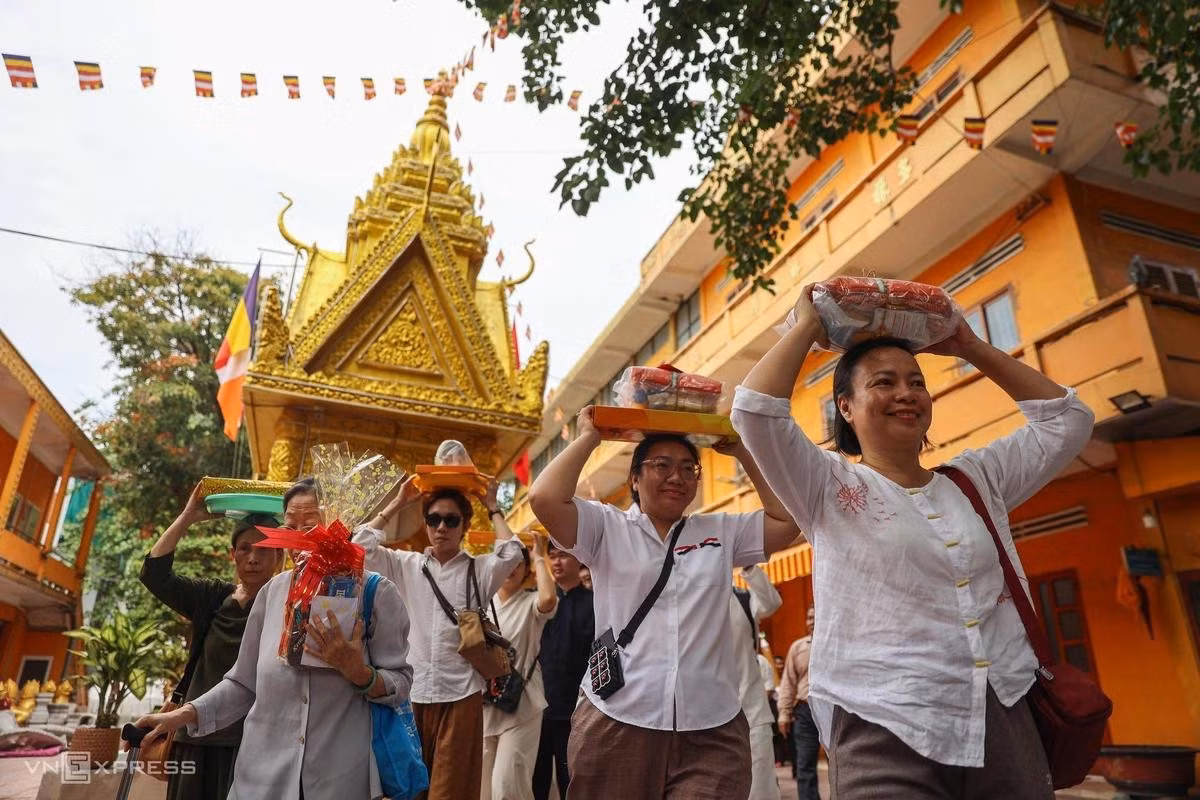 La procession rituelle dure une dizaine de minutes. Les fidèles portent leurs offrandes sur la tête et avancent lentement autour du sanctuaire dans une atmosphère empreinte de recueillement. Photo : VnExpress