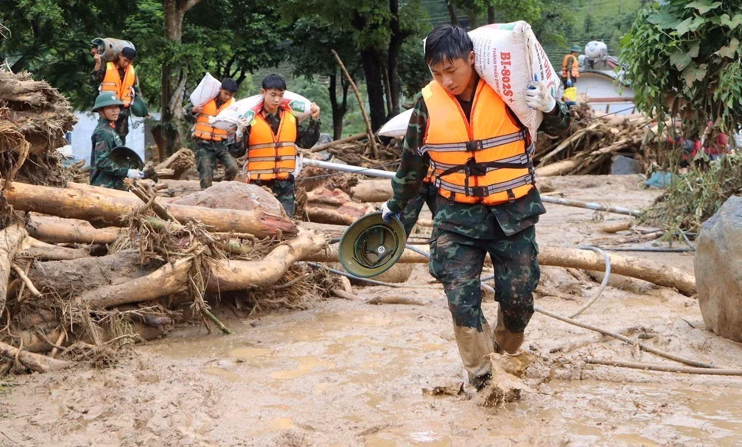 Les forces militaires aident les habitants à enlever la boue, les pierres et les débris charriés dans leurs maisons dans la commune de Muong Than. Photo : VNA