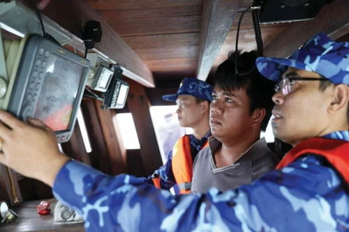 Vérification d’un dispositif de suivi installé à bord d’un bateau de pêche. Photo : VNA.