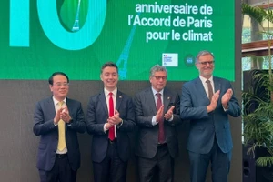 Des délégués lors de la conférence de presse pour célébrer le 10ᵉ anniversaire de la signature de l’Accord de Paris sur le climat, le 11 décembre à Hanoi. Photo : NDEL.