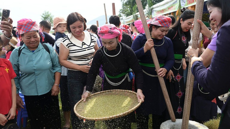 Des touristes participent à la fabrication de cốm. Photo : NDEL d.jpg